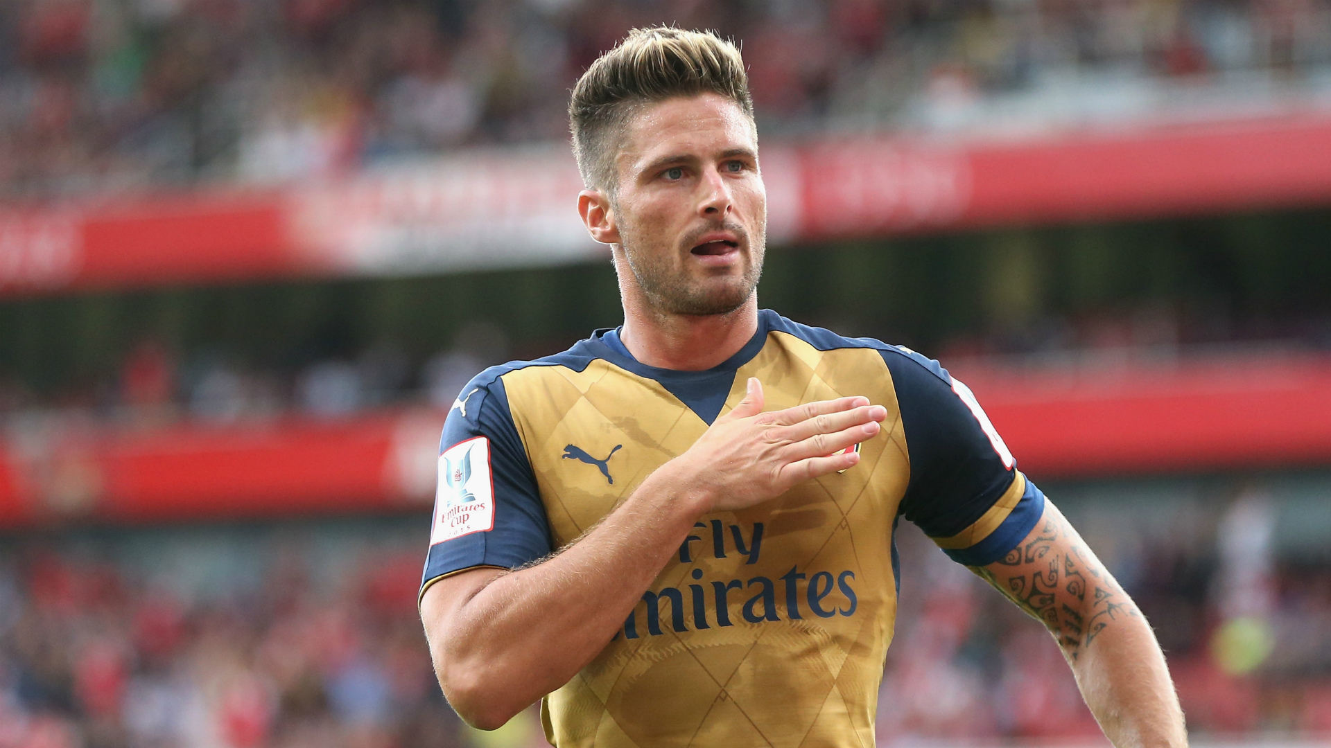 Olivier Giroud taps Arsenal badge