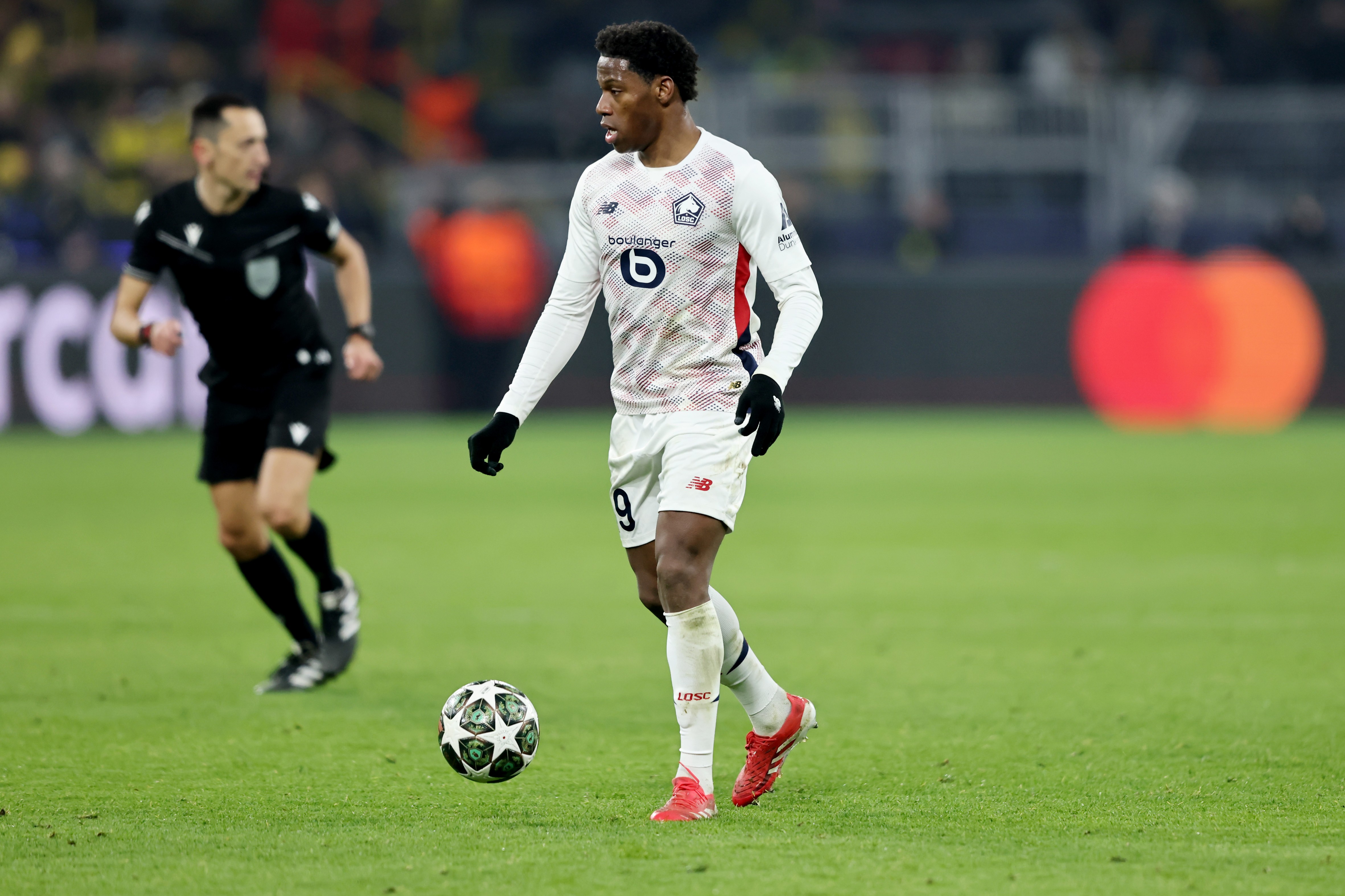 Jonathan David of Lille runs with the ball