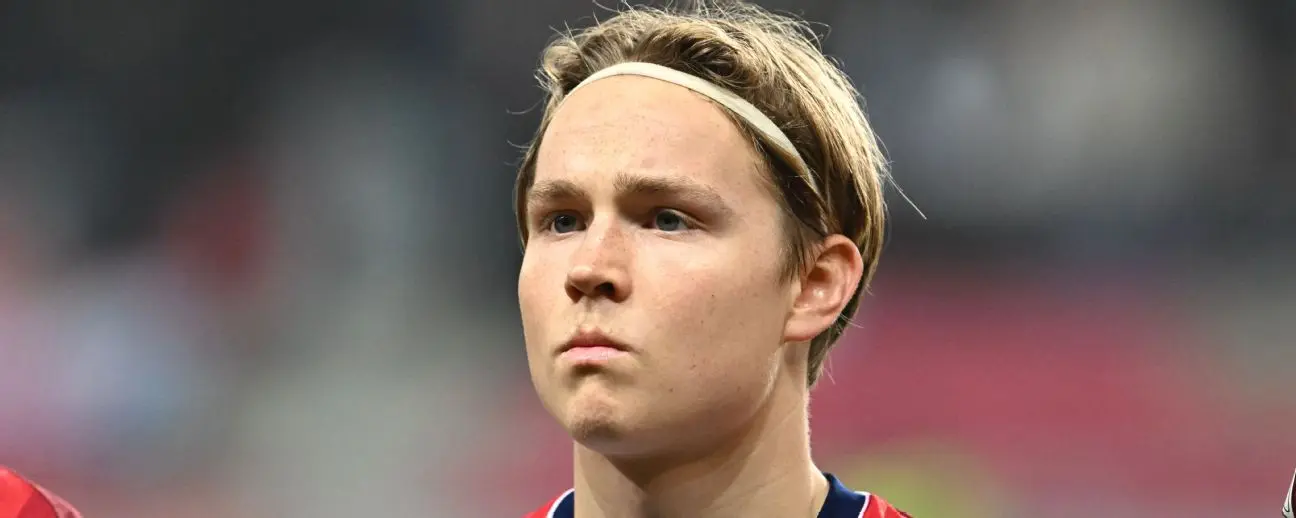 Close-up of a young male football player with a headband, serious expression.
