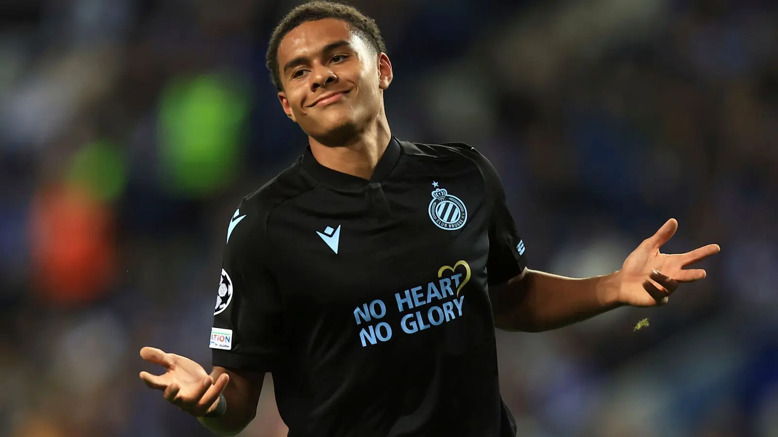 Antonio Nusa celebrating in a black Club Brugge jersey on the field.