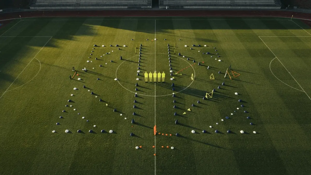 Aerial view of football training pitch with tactical passing drill patterns and navy training equipment