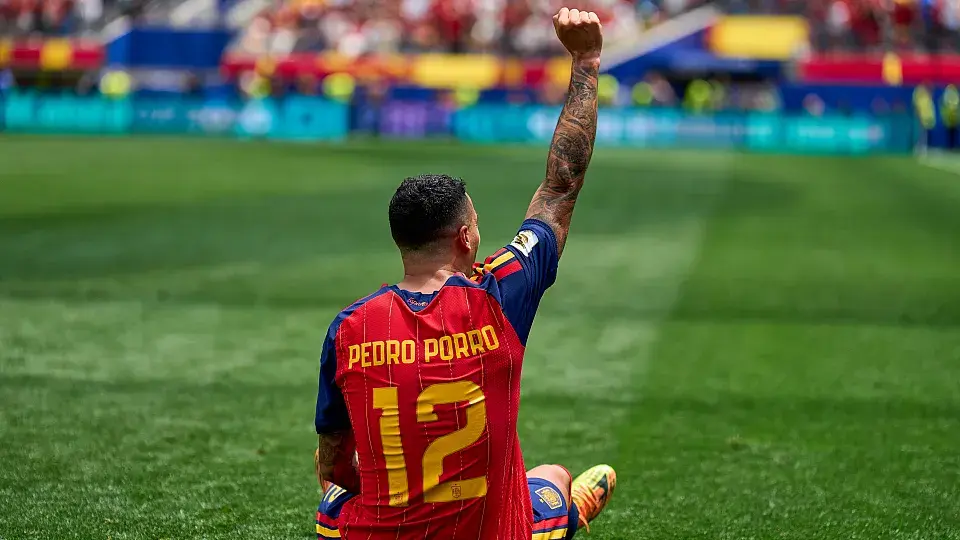 Pedro Porro celebrating wearing Spain national team jersey with raised fist.