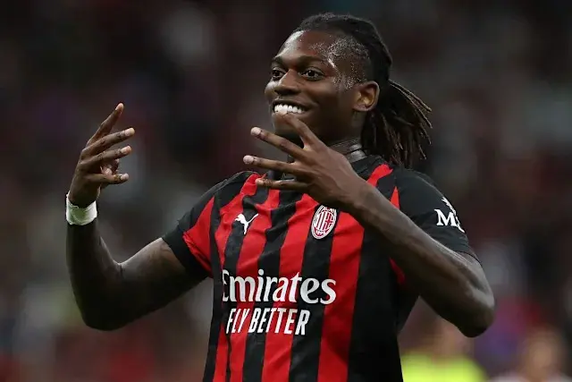 Rafael Leao celebrating in an AC Milan jersey with a joyful expression.