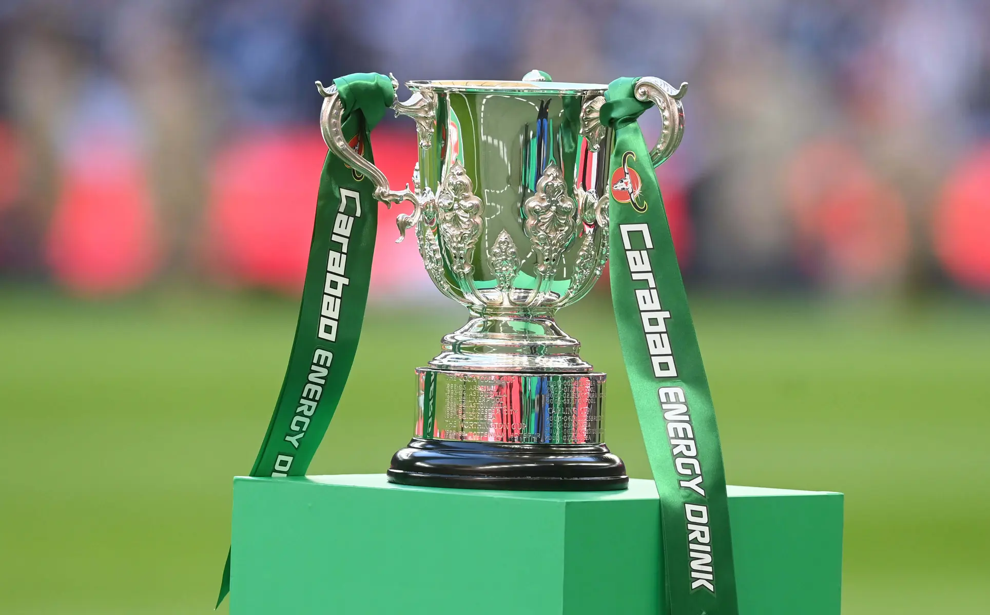 The silver Carabao Cup EFL trophy with green Carabao Energy Drink ribbons on a green pedestal