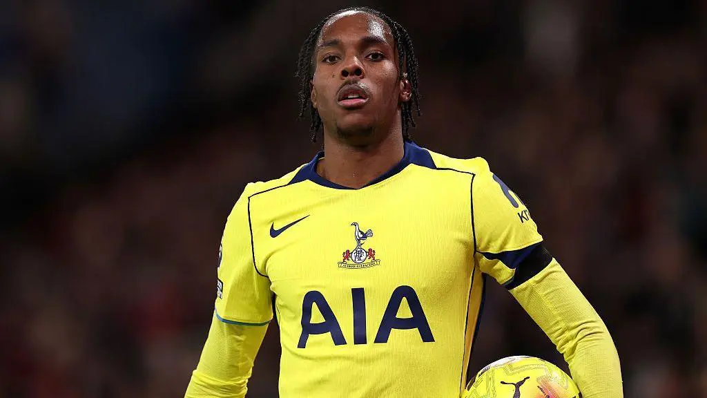 Professional soccer player in a yellow Tottenham Hotspur jersey with AIA sponsor logo