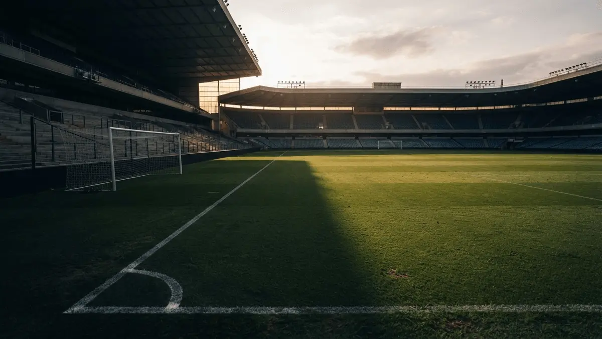 Empty football pitch left-back zone at sunset with tactical markings and navy shadows