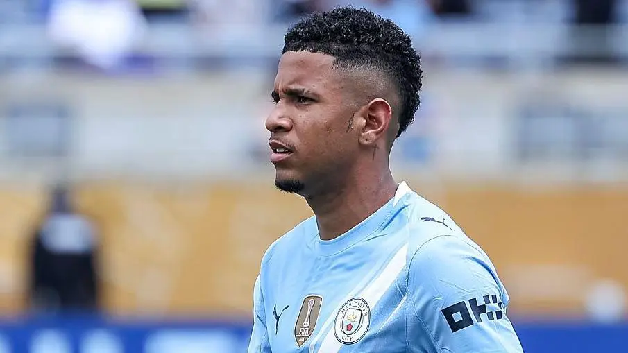 Close-up profile of Savinho wearing the Manchester City light blue home kit.