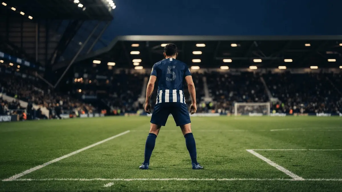 Football defender in tactical position on stadium pitch with dramatic lighting