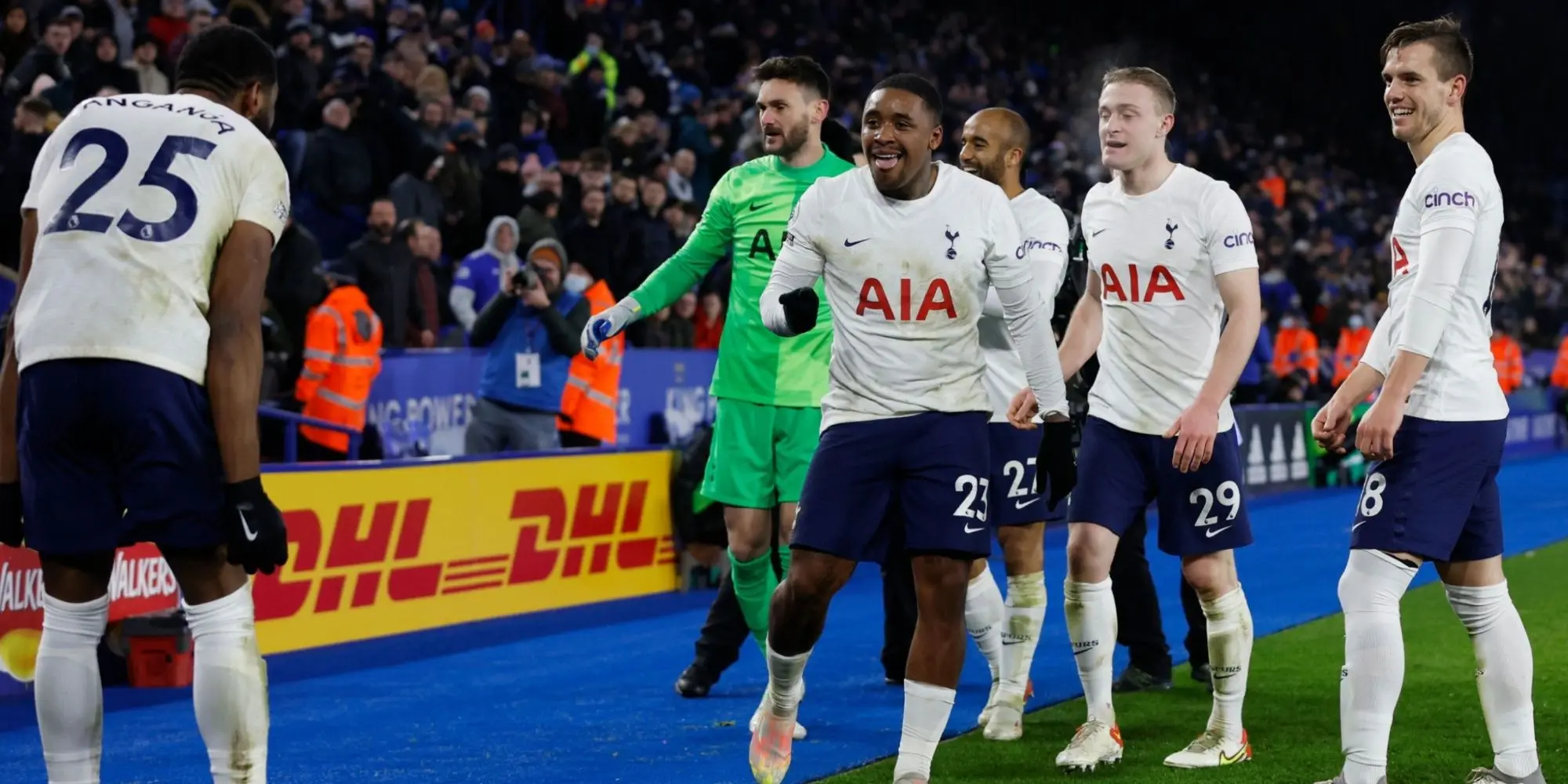 Tottenham Hotspur players in white home kits celebrating on the pitch during a Premier League match.