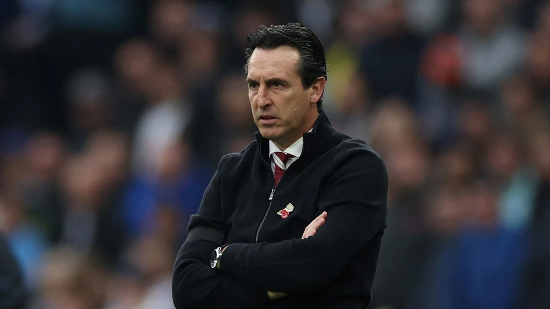 Unai Emery standing with arms crossed during a football match.