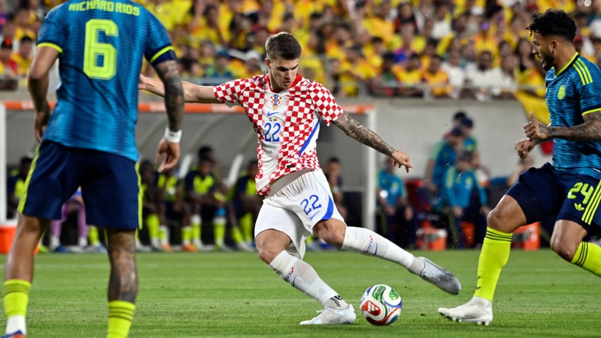 Igor Matanović in a Croatia national team kit kicking a soccer ball during a match against Colombia.