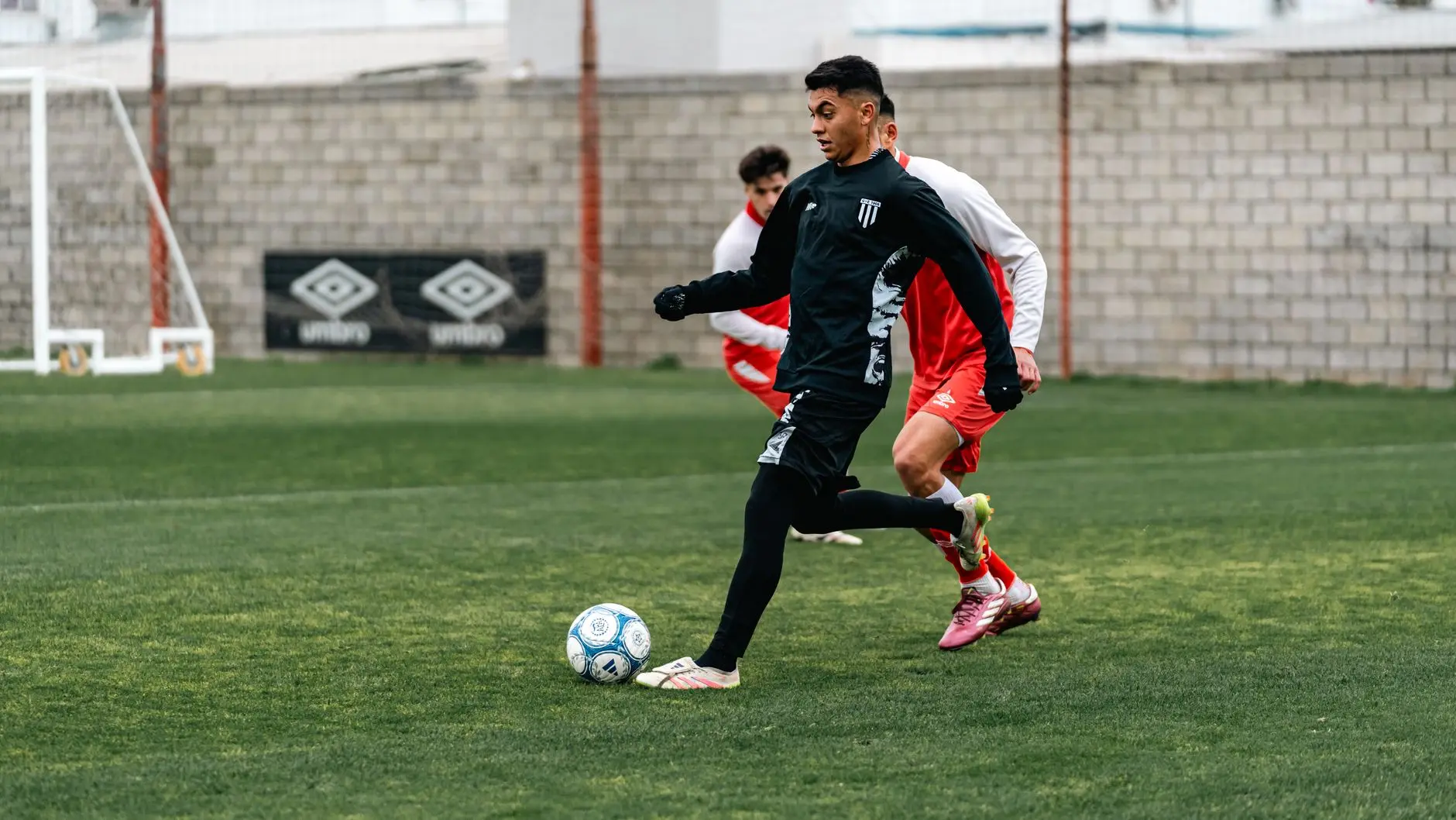 Omar Marmoush dribbling a soccer ball during a training session wearing black athletic gear