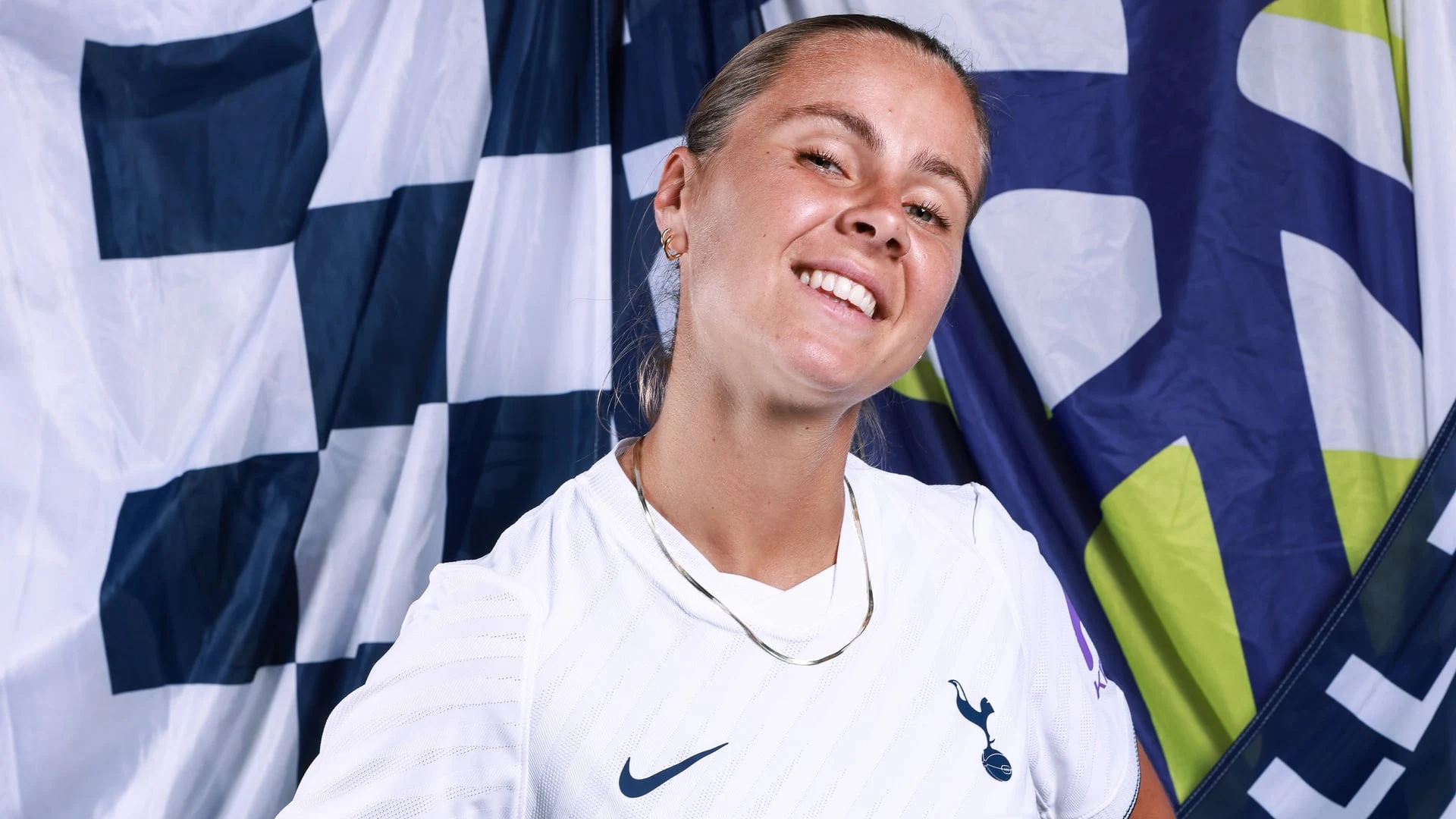 Victoria Pelova smiling in a Tottenham Hotspur white home kit