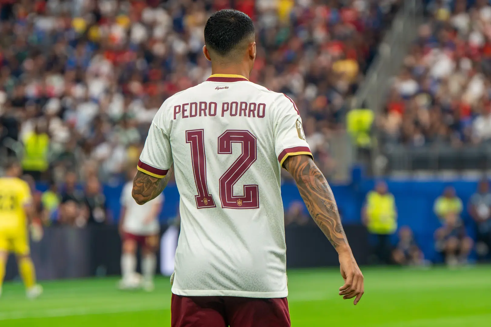Rear view of Pedro Porro wearing a white football jersey with his name and number 12 on the back.